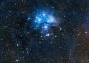 Les Plèiades (M45), amb les seves nebulositats, i el núvol de pols que l'envolta